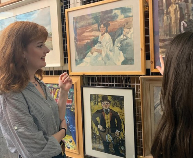 Volunteer and Curator of University Art Collections looking through artworks in storage