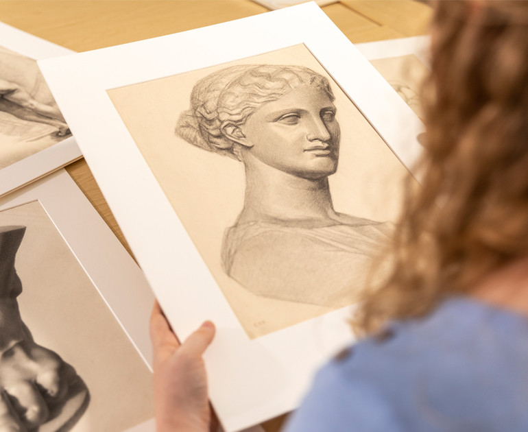 Looking over the shoulder of a researcher, looking at a drawing by Minnie Jane Hardman