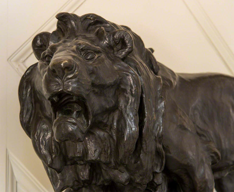 Closeup of the head of a bronze lion with open mouth