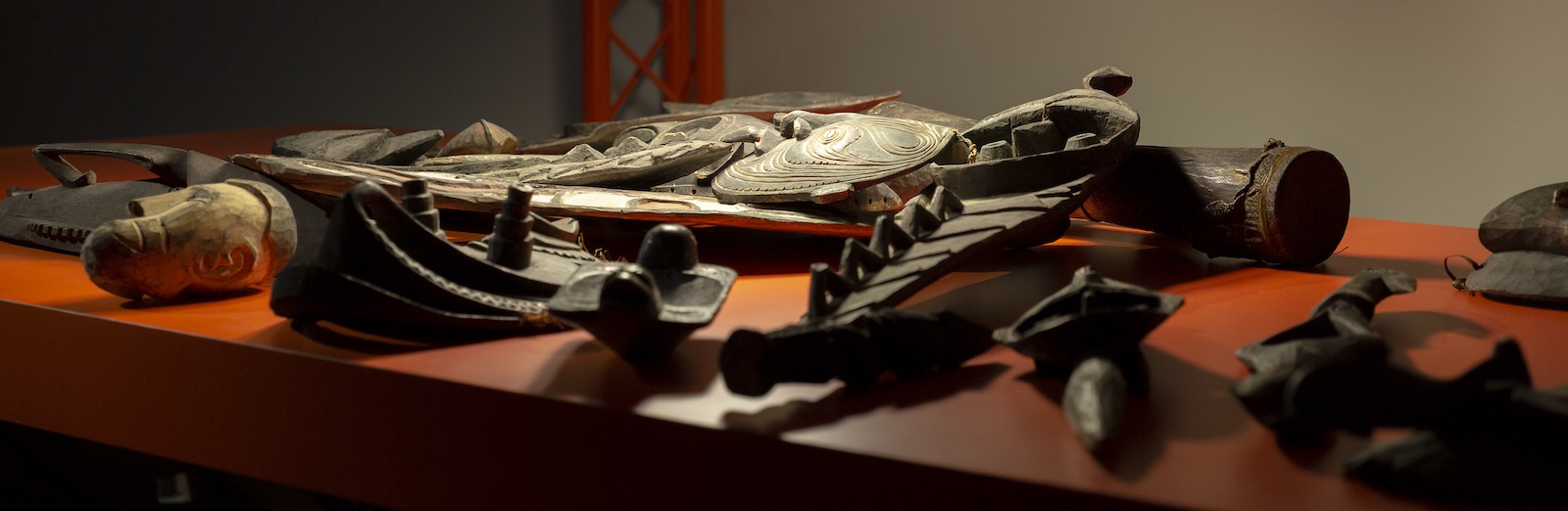 Closeup of wooden masks on an orange surface