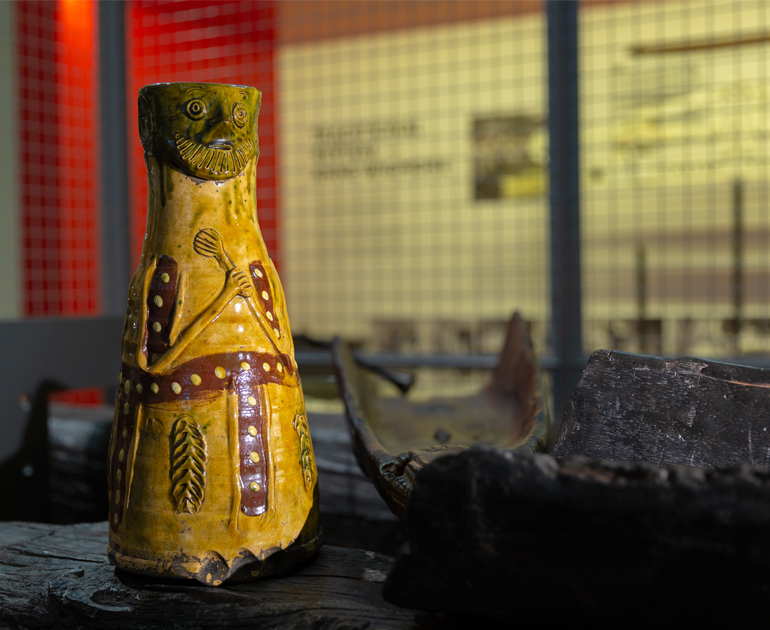 Figurative pot inside a cage and balanced on a fake log