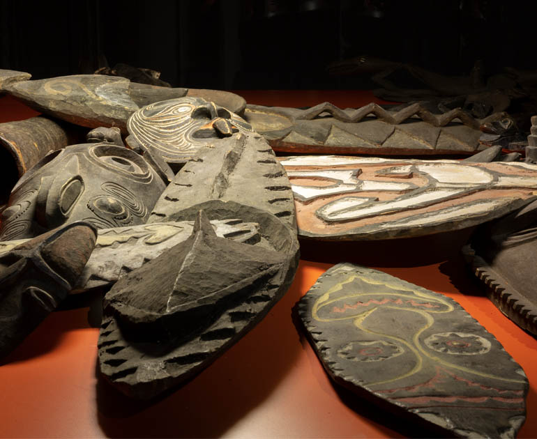 Closeup of wooden masks on an orange surface