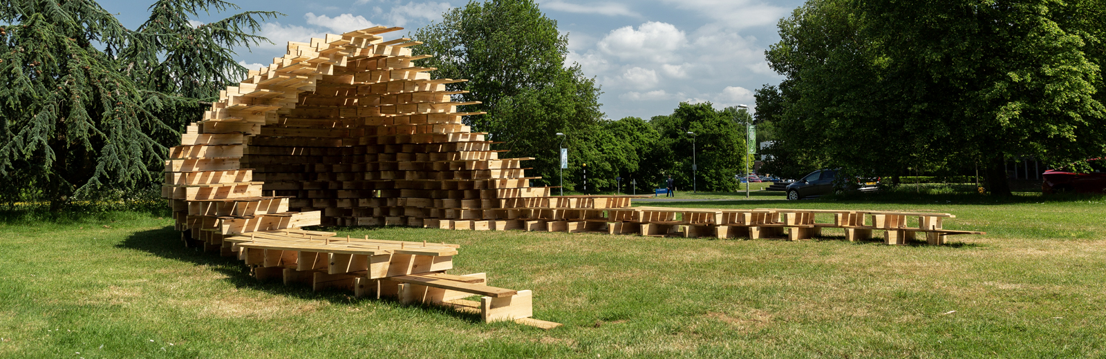 Wooden structure with two extended arms and a curved central section with a roof