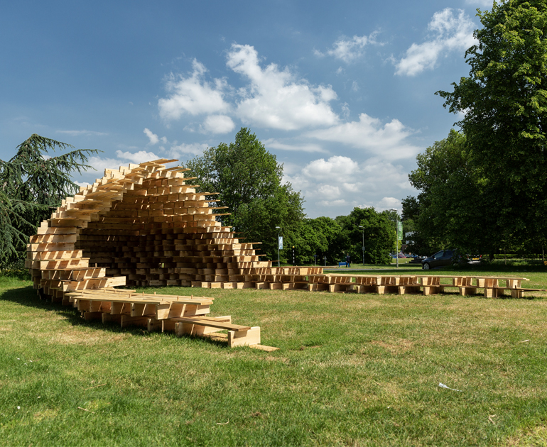 Wooden structure with two extended arms and a curved central section with a roof