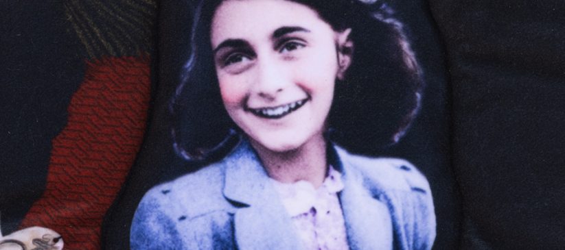 Photo of Anne Frank on a multi-coloured wall hanging
