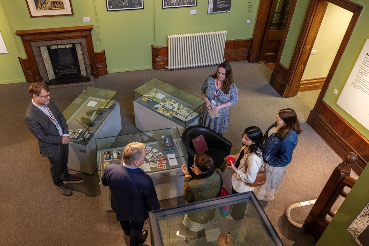 A photo from above showing people discussing displays in the new staircase hall