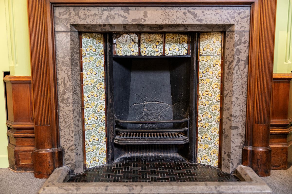 Fireplace in the staircase hall at The MERL with tiles designed by William De Morgan (1839-1917)