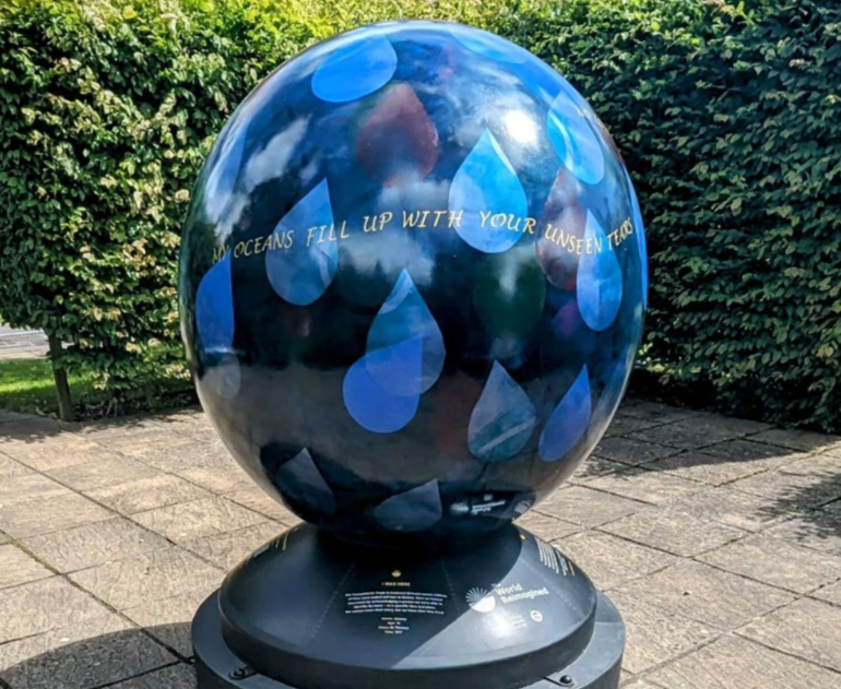 Painted globe with tear motif and the words 