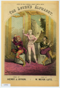 A sumptuous stage setting with three figures in costume (from Little Doctor Faust?), including Miss Warren in 18th century[?] pink men's attire. 