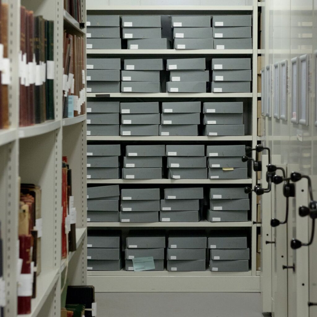 Rows of grey archival boxes containing the Mills & Boon archive on storage shelves