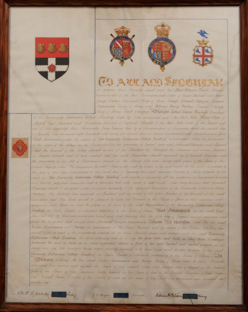Framed parchment document featuring coats of arms and ornate calligraphy.